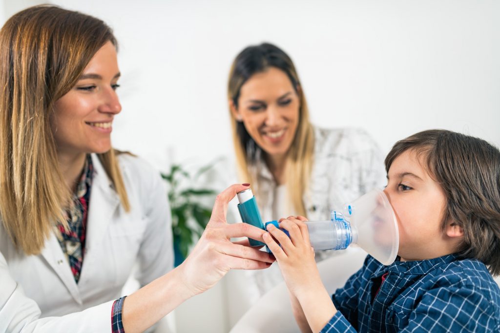 Doctor Helping Little Boy with Inhaler