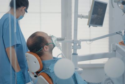 Dental assistant using oxygen mask to do anesthesia on patient
